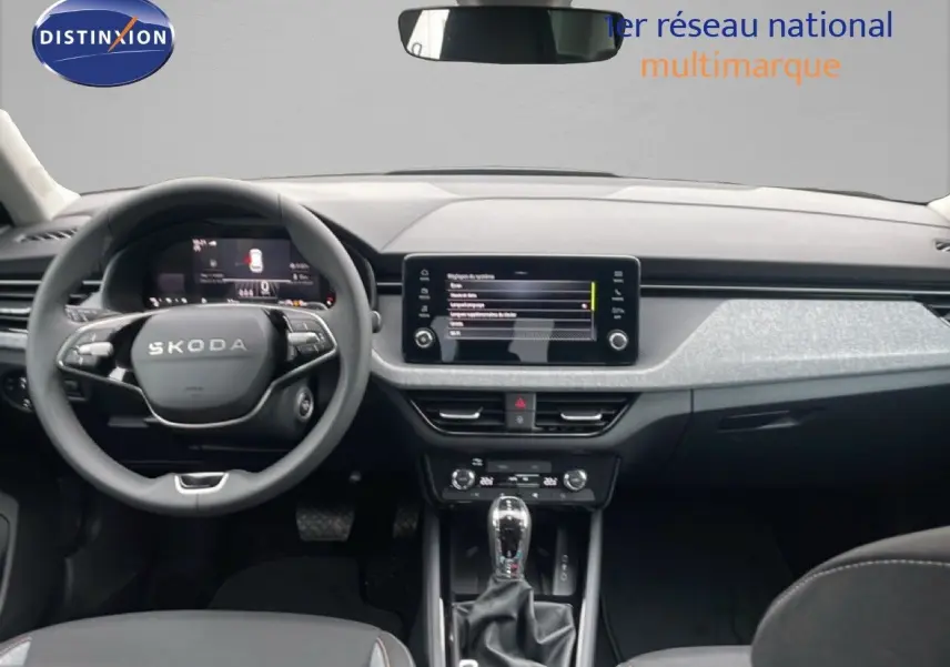Vue intérieure frontale du tableau de bord et volant SKODA KAMIQ 2025, finition gris graphite avec écran tactile central.