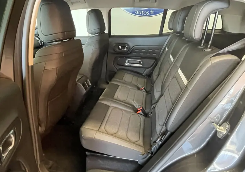 Vue intérieure côté droit des sièges arrière en tissu gris du Citroën C5 Aircross hybride 2025, avec portes ouvertes.