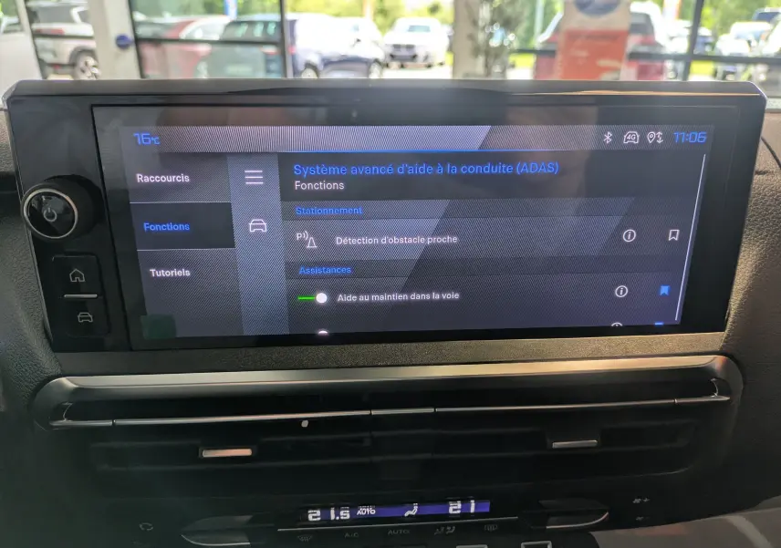 Écran tactile du système d’aide à la conduite dans l’habitacle d’un Peugeot Traveller noir, vue intérieure frontale.