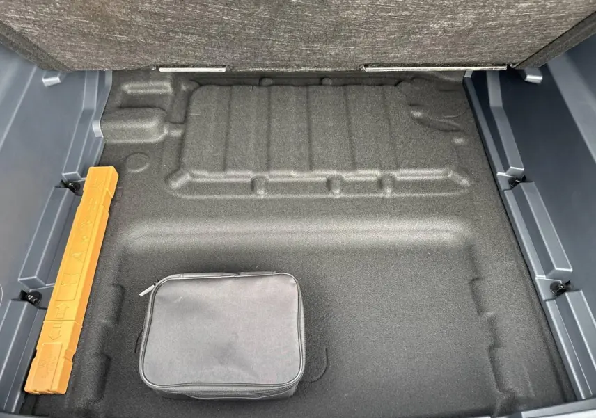 Vue plongeante sur le coffre vide du Geely STARRAY 1.5 EM-i 262ch Max+ en Volcanic Grey, avec trousse noire.
