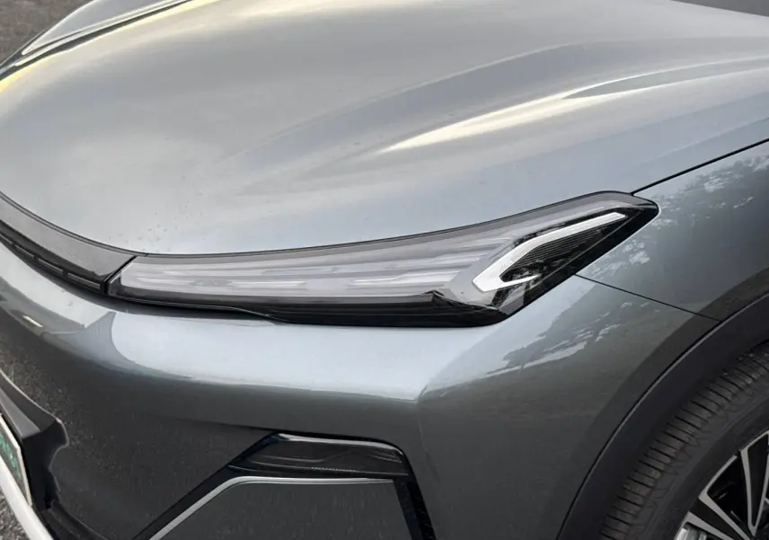 Gros plan sur l'avant droit du Geely STARRAY 1.5 EM-i 262ch Max+ en Volcanic Grey Metallic, mettant en valeur le phare LED.