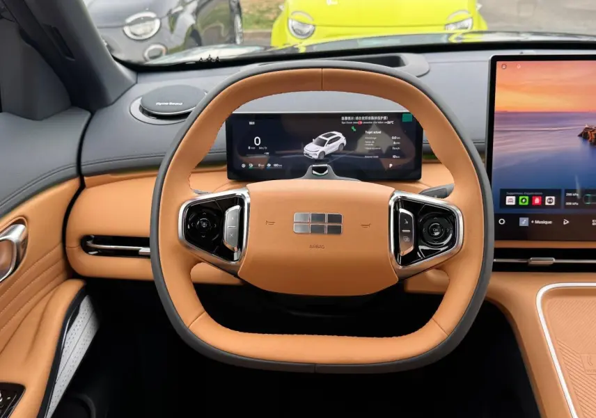 Vue intérieure centrée sur le volant cuir beige et les écrans numériques du tableau de bord du Geely STARRAY 2026.