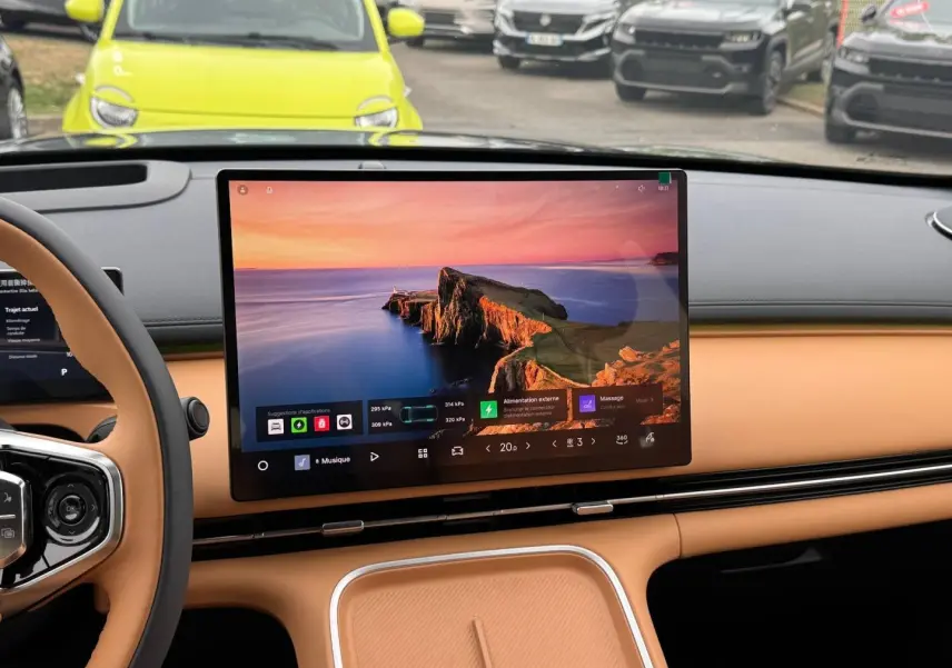 Vue intérieure du tableau de bord beige du Geely STARRAY 1.5 EM-i avec grand écran tactile central allumé.