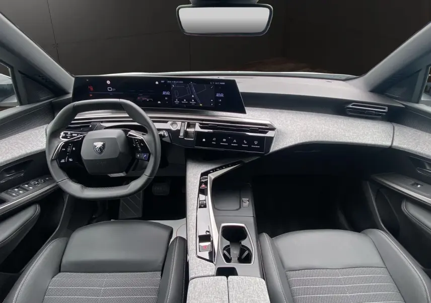 Intérieur noir et gris du Peugeot 3008 2024, vue de face sur le tableau de bord et le volant compact.