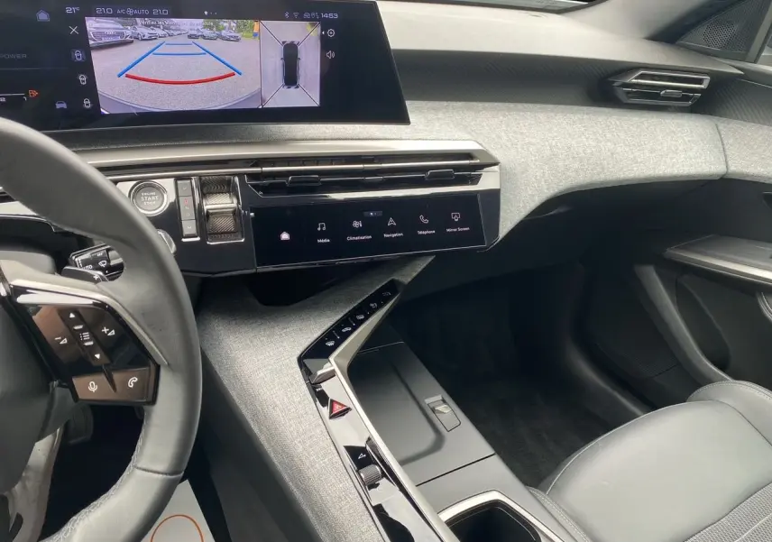 Intérieur moderne du Peugeot 3008 2024, vue côté passager avec écran tactile et volant partiel noir.