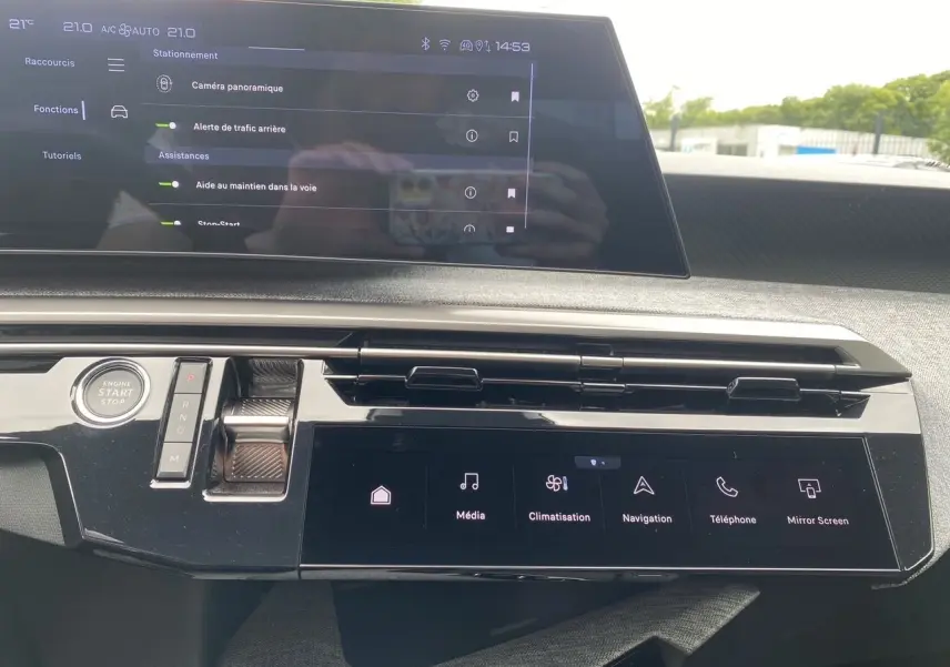 Tableau de bord du Peugeot 3008 hybride 2024 avec écran tactile panoramique et commandes modernes en vue frontale rapprochée.