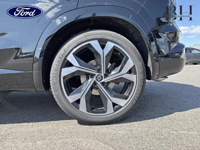 Gros plan sur la roue avant droite noir étoilé du Renault Austral 1.2 E-Tech full hybrid 200ch avec jante alu Alpine.