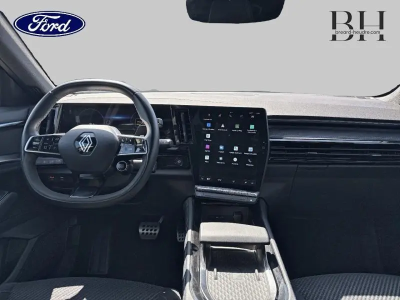 Intérieur avant du Renault Austral noir étoilé, tableau de bord moderne avec grand écran tactile vertical et volant multifonction.