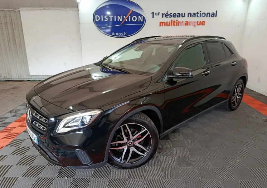 Mercedes GLA 220 d noir vue 3/4 avant droit, avec jantes alliage et phares LED dans un showroom intérieur.