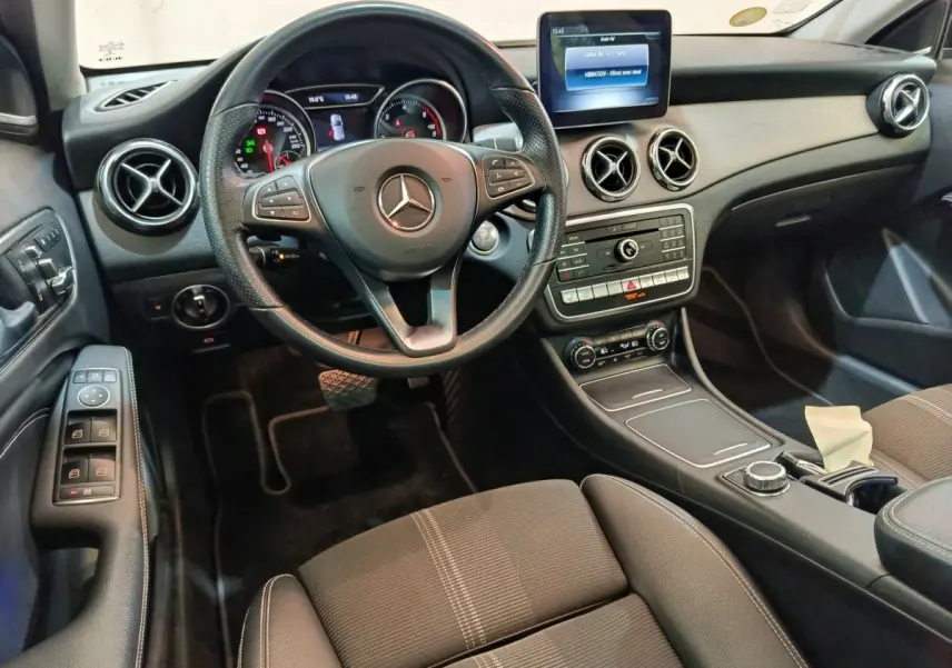 Intérieur noir du Mercedes GLA 220 d 2018 vu côté conducteur, volant cuir et écran multimédia central visible.