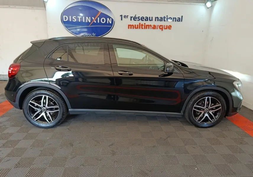 Mercedes GLA 220 d noir vue de profil côté gauche, avec jantes alliage et toit panoramique visible en intérieur showroom.