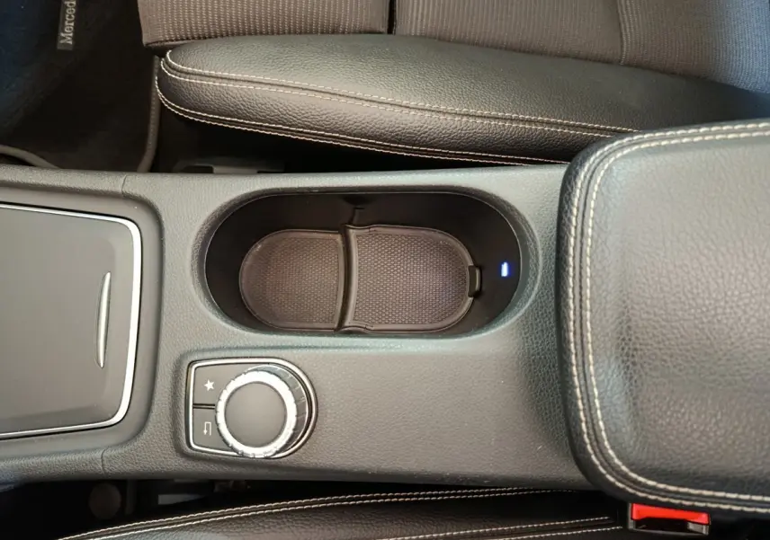 Vue rapprochée de la console centrale noire du Mercedes GLA 220 d avec molette de contrôle et accoudoir en cuir.