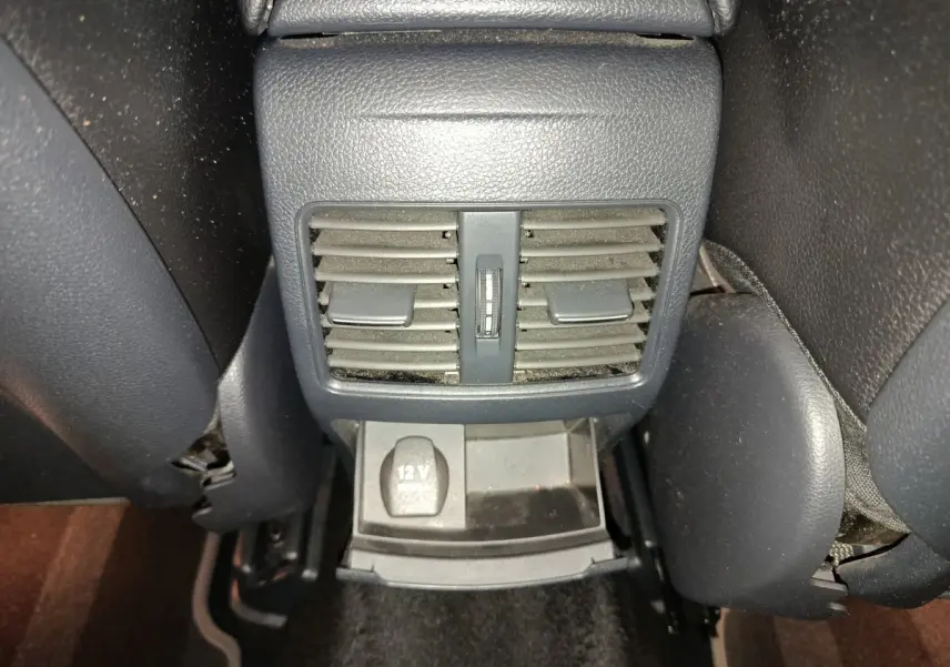 Gros plan sur la console arrière noire du Mercedes GLA 220 d 2018 avec bouches d'aération et prise 12V visible.