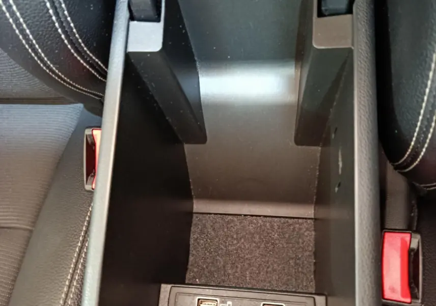 Vue plongeante sur le rangement central noir avec ports USB entre les sièges en cuir noir du Mercedes GLA 220 d 2018.