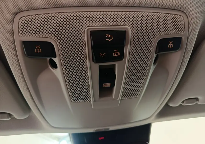 Vue en contre-plongée du panneau de commandes plafonnier beige clair dans l'habitacle du Mercedes GLA noir 2018.