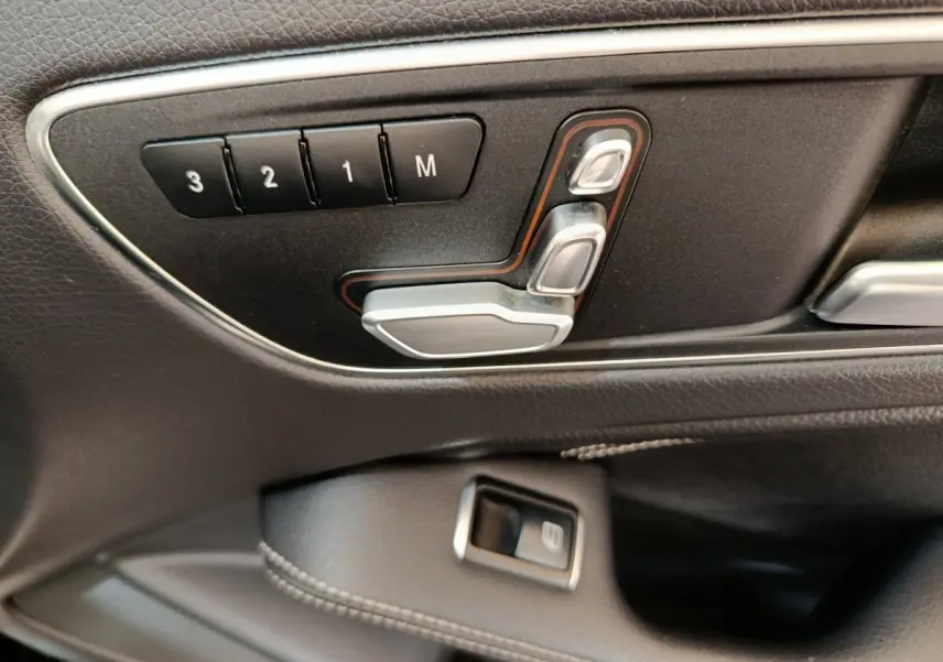 Détail des commandes de réglage de siège en cuir noir côté gauche dans une Mercedes GLA 220 d Business Exec 2018.