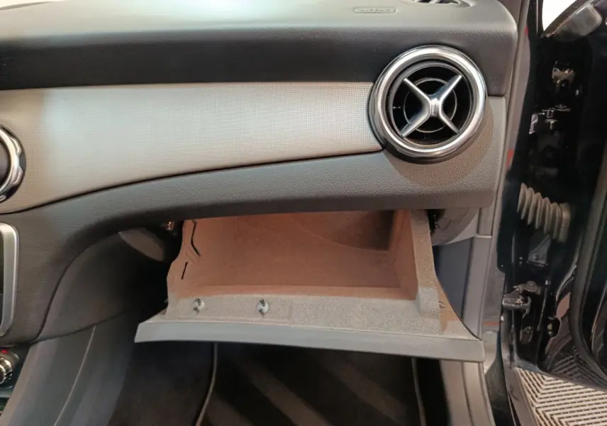 Vue intérieure côté passager du tableau de bord noir d'un Mercedes GLA 220 d 2018 avec boîte à gants ouverte.