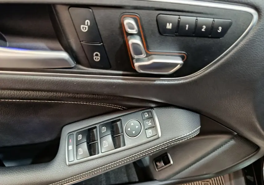 Gros plan sur la porte côté conducteur du Mercedes GLA noir, avec commandes électriques et réglages mémoire des sièges.