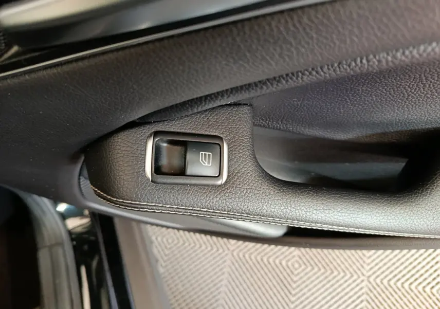 Gros plan sur la commande de lève-vitre côté gauche en cuir noir avec surpiqûres dans une Mercedes GLA 220 d Business Exec 2018.