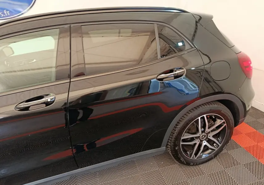Vue latérale côté droit d'un Mercedes GLA 220 d noir avec jantes alliage et poignées chromées.
