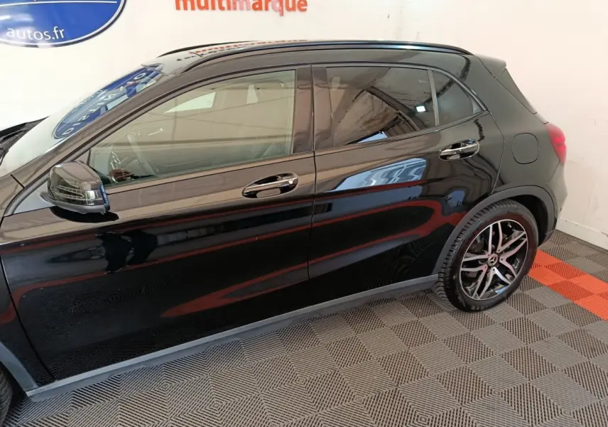 Vue latérale côté gauche d'une Mercedes GLA 220 d Business Exec noire, soulignant ses jantes alliage et rétroviseurs chromés.