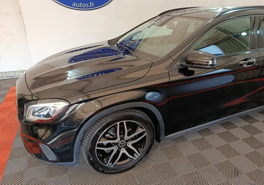 Vue de 3/4 avant droit d'un Mercedes GLA 220 d noir brillant avec jantes alliage et rétroviseurs intégrant clignotants.