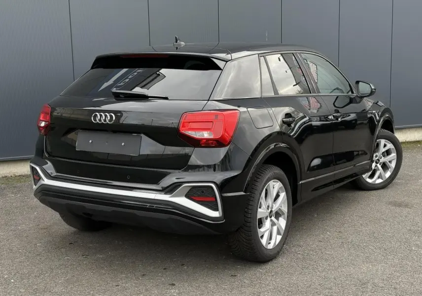 Audi Q2 35 TFSI S-Line noir Mythe vue 3/4 arrière droit, hayon électrique et feux arrière LED visibles