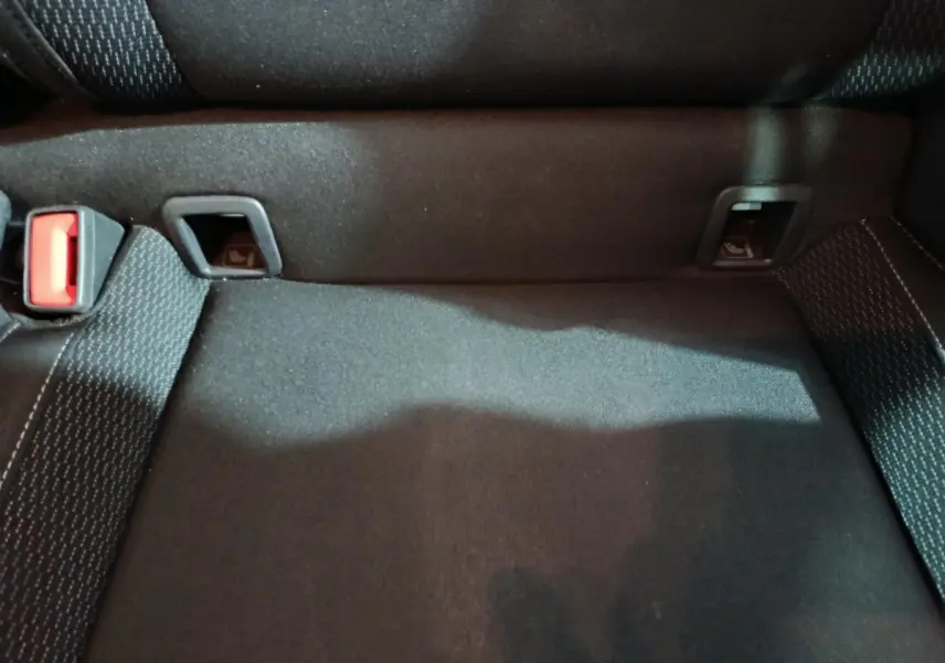 Gros plan sur la banquette arrière noire du Skoda Karoq 2024, montrant les fixations Isofix et la ceinture rouge.