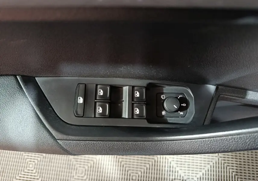Commande des vitres et réglage des rétroviseurs côté gauche dans l'habitacle noir du Skoda Karoq 2024.