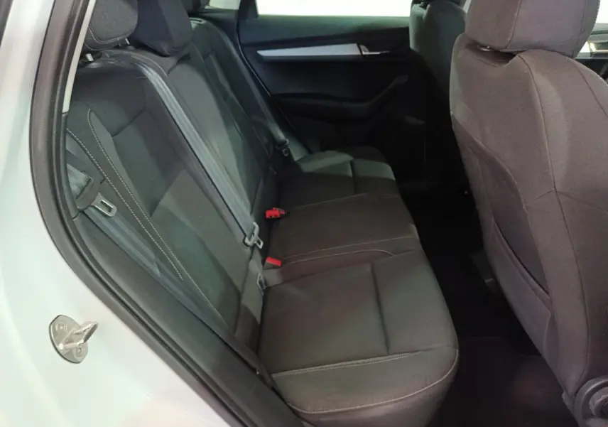 Vue intérieure côté gauche des sièges arrière noirs du Skoda Karoq 2024, montrant la banquette et les appuie-têtes.