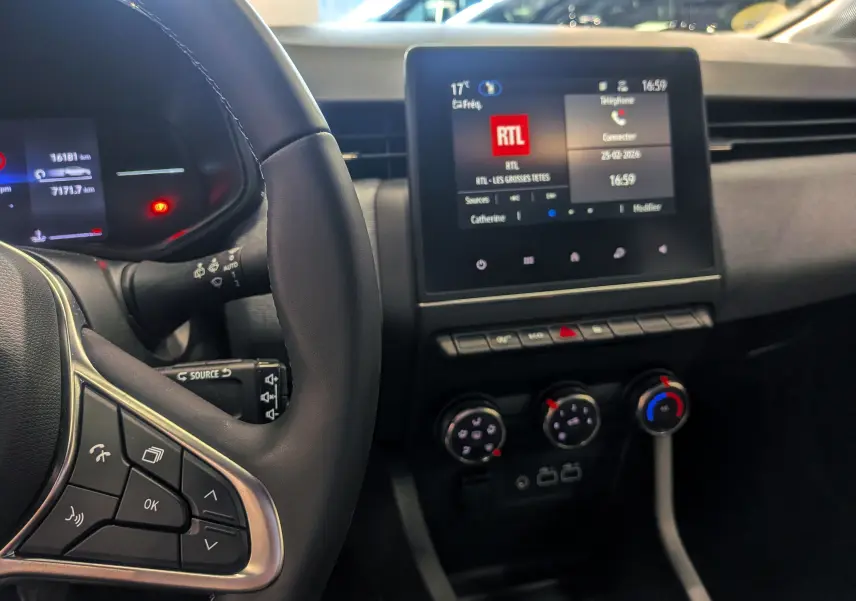 Vue intérieure centrée sur le volant et l’écran tactile du tableau de bord de la Renault Clio V 2024.