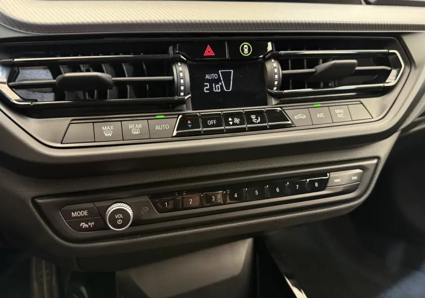 Détail du tableau de bord noir de la BMW Série 1 120i Edition M Sport Pro avec commandes climatisation et multimédia.