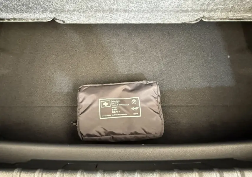 Vue plongeante sur le coffre noir d’une BMW Série 1 120i Edition M Sport Pro avec trousse de secours noire.