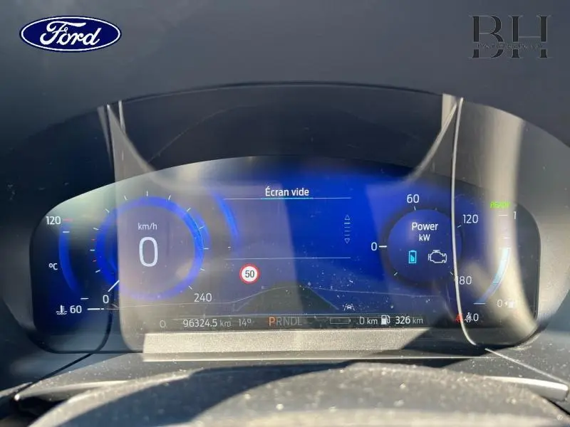 Tableau de bord numérique du Ford Kuga hybride rechargeable 2022, affichage bleu avec vitesse et puissance en kW.