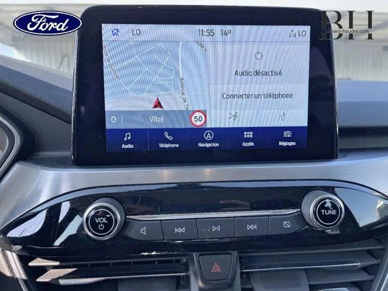 Écran tactile central du Ford Kuga 2022 avec navigation affichée et commandes audio intégrées en tableau de bord noir.