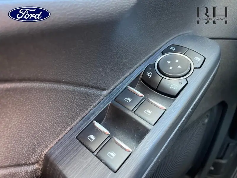 Gros plan sur les commandes de lève-vitres et rétroviseurs côté conducteur du Ford Kuga gris Magnetic 2022 Titanium PHEV.