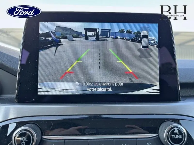 Écran tactile du Ford Kuga 2022 affichant la caméra de recul avec lignes de guidage colorées et vue arrière du parking.