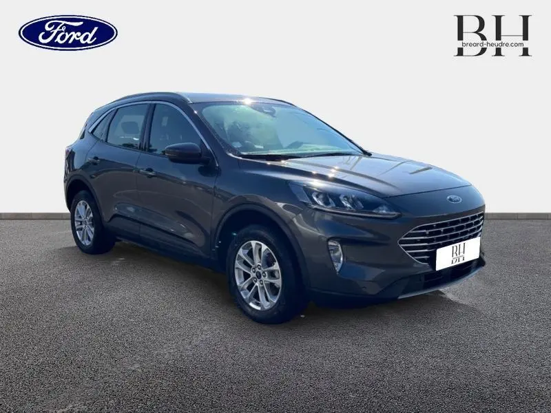 Ford Kuga hybride rechargeable gris Magnetic en vue 3/4 avant droit, avec jantes alliage et calandre distinctive.