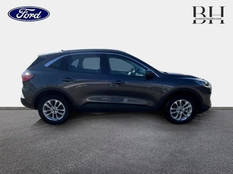 Profil côté gauche du Ford Kuga 2022 gris Magnetic Métallisé, SUV hybride rechargeable avec jantes alu visibles.