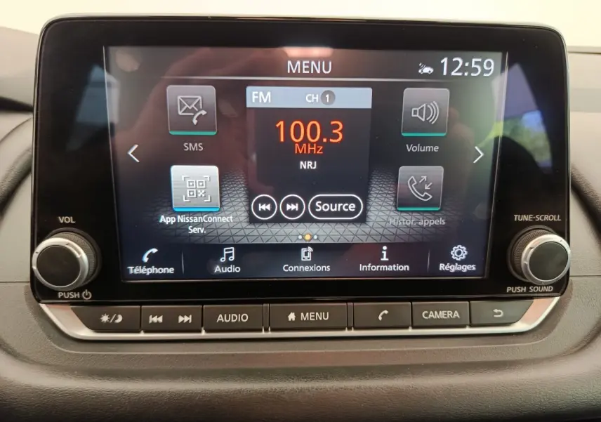 Écran tactile central du Nissan Qashqai e-Power 2024 affichant la radio FM 100.3 MHz avec commandes physiques en dessous.