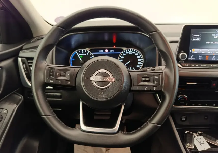 Vue centrée sur le volant cuir noir du Nissan Qashqai e-Power 2024 avec tableau de bord et écran tactile visibles.