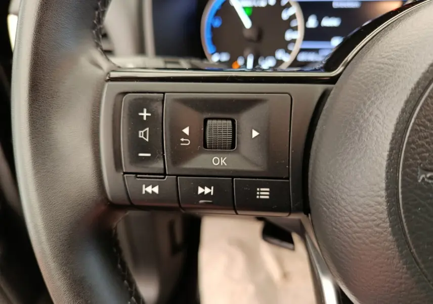 Gros plan sur les commandes multifonctions noires à gauche du volant cuir du Nissan Qashqai e-Power 2024.