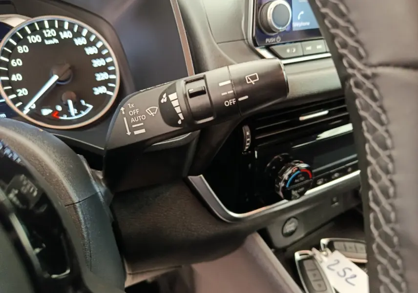 Vue rapprochée du commodo d’essuie-glace et du tableau de bord du Nissan Qashqai e-Power noir, avec volant partiel visible.