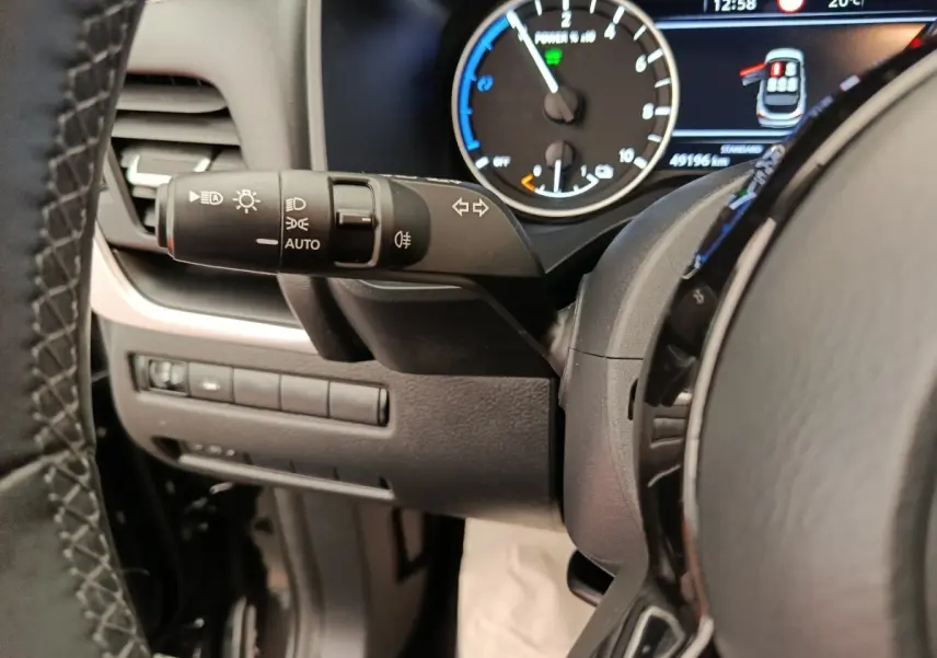 Gros plan sur la manette de commande des phares et clignotants côté gauche du tableau de bord du Nissan Qashqai noir 2024.