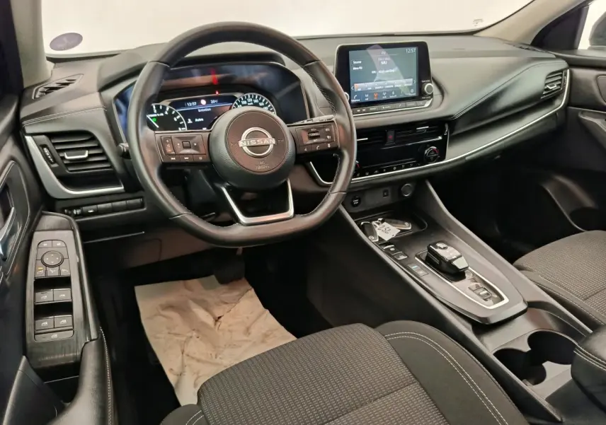 Vue intérieure du poste de conduite du Nissan Qashqai e-Power 190 Business Edition BVA 2024, avec volant cuir multifonctions et écran tactile central.