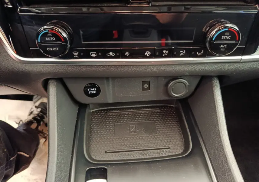 Gros plan sur la console centrale noire du Nissan Qashqai e-Power 2024 avec commandes climatisation et bouton start/stop.