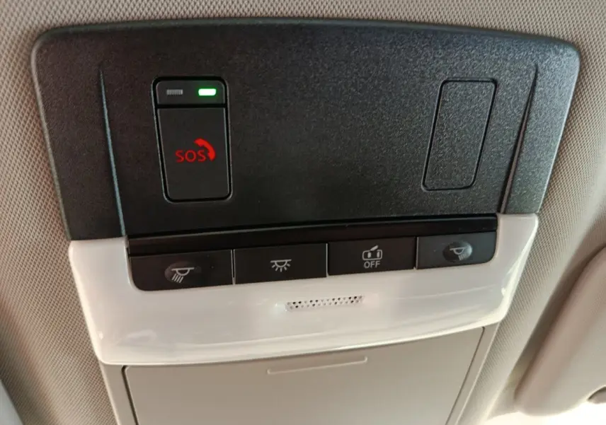 Vue rapprochée du plafonnier intérieur noir et beige du Nissan Qashqai 2024 avec bouton SOS rouge et commandes d’éclairage.