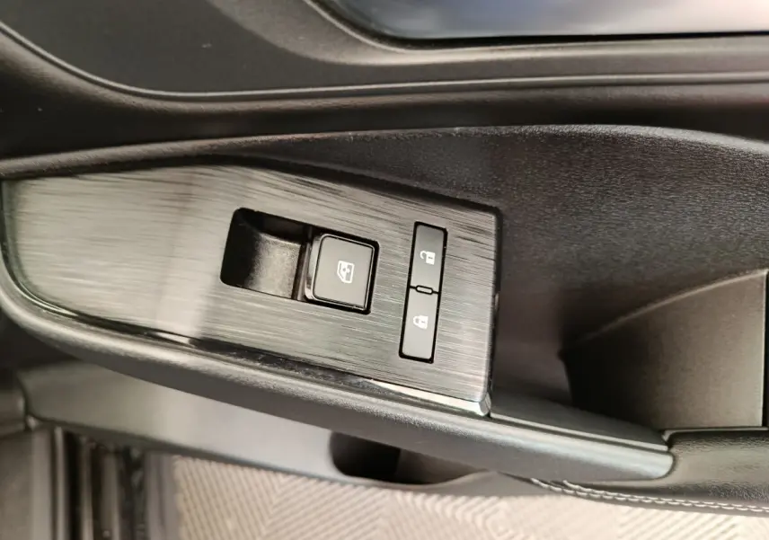 Détail des commandes de lève-vitre et verrouillage sur la porte côté conducteur du Nissan Qashqai e-Power noir 2024.