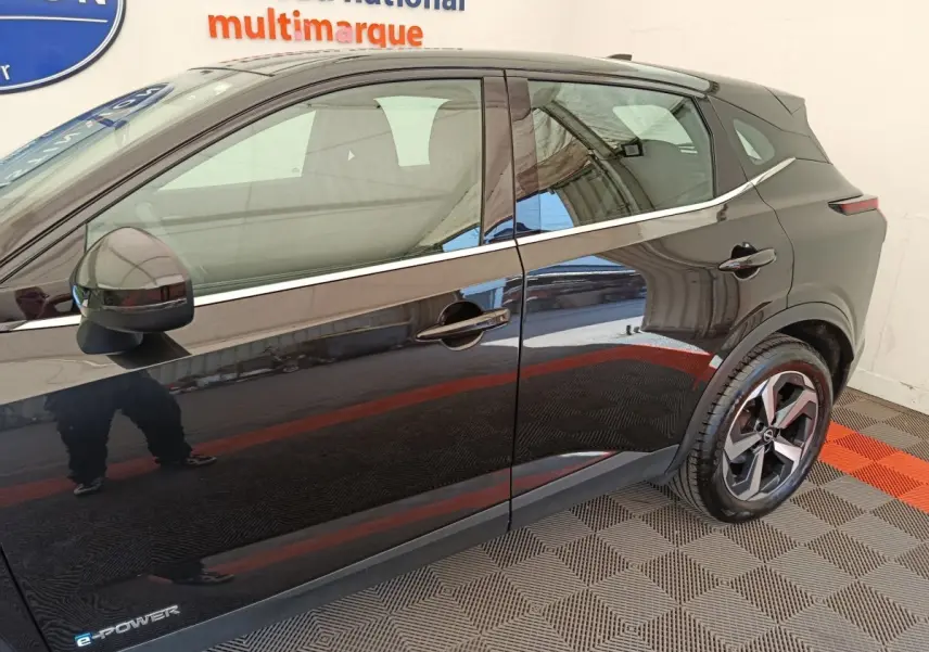 Profil côté gauche du Nissan Qashqai e-Power noir 2024 avec jantes alliage et logo e-Power visible sur la porte avant.