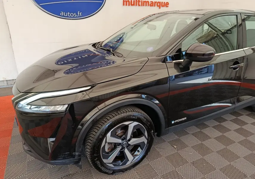 Vue 3/4 avant droit du Nissan Qashqai e-Power noir, mettant en valeur ses phares LED et jantes alliage distinctives.